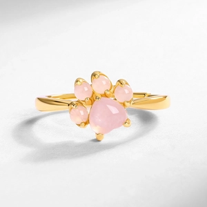 Macro shot of a pink rose quartz cat paw stone set in a minimalist gold-plated ring