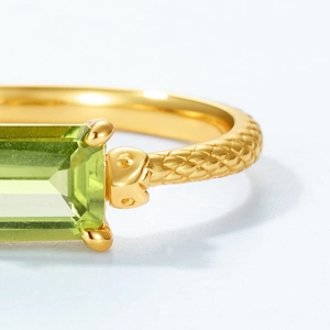 Macro detail of rectangle green peridot ring with snakeskin textured gold band