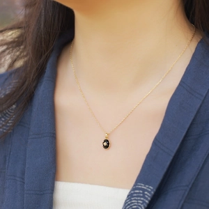Collier rétro en argent S925 avec pendentif onyx ovale et fleur dorée sur modèle
