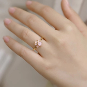 Detailed view of a sweet cat paw open ring with pink crystal on a model hand