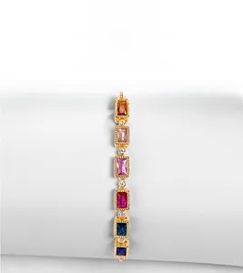 Detail of vintage-style gold bracelet featuring multi-colored rectangular cut gemstones