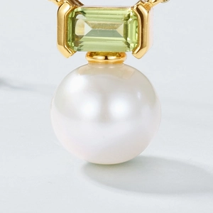 Macro detail of S925 silver pendant with green gemstone and round freshwater pearl