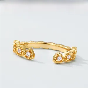 Dettaglio macro di un anello in argento S925 dorato con zirconi bianchi e montatura a corona