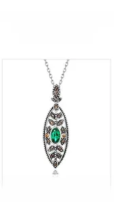 Macro shot of vintage S925 silver emerald pendant necklace with antique finish
