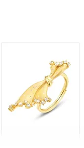 Détail de la bague en forme de jupe dorée brossée avec cristaux pavés et anneau ajustable