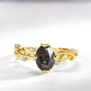 Makroaufnahme: Ring mit schwarzem Rutilquarz und goldvergoldeter S925-Silber-Weinrebe