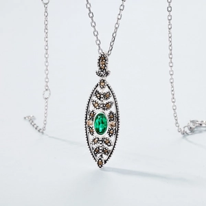 Vintage S925 silver necklace with emerald-green stone and champagne accents on blue background