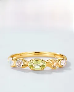 Detailed close-up of a S925 silver gold-plated ring with natural peridot and opal stones
