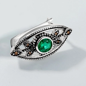 Dettaglio macro dell'anello retrò in argento a forma di occhio con smeraldo e pietre
