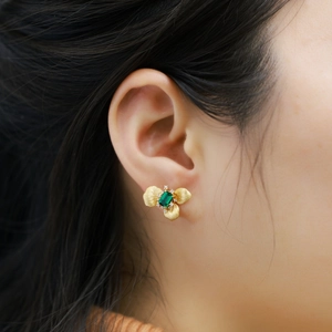 Pendientes de flores con esmeralda en plata S925 bañada en oro cepillado sobre modelo