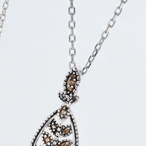 Macro view of S925 sterling silver necklace with retro emerald and amber stones