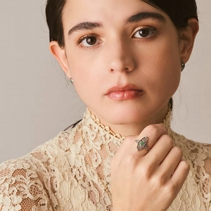 Vintage 925 sterling silver leaf ring with emerald gemstone shown on model's hand