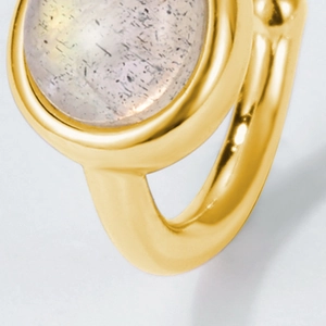 Macro shot of gold S925 silver ear cuff with cabochon labradorite in bezel setting