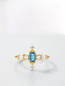Detail of London Blue Topaz ring in gold finish featuring rectangle cut and zircon accents