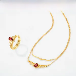 Detail of garnet teardrop pendant and crown ring set in gold plated S925 silver