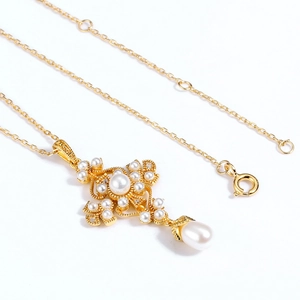 Détail du collier croix dorée avec perles d'eau douce et petits diamants brillants