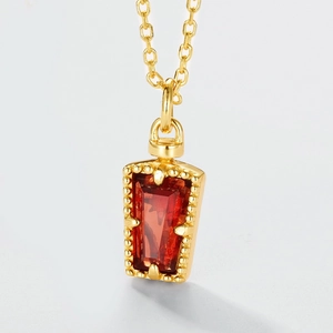 Détail macro du pendentif rectangulaire rouge avec bordure dorée perlée sur chaîne