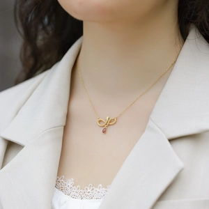 Elegant gold snake pendant necklace with garnet teardrop and green gem accents for women