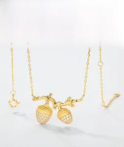 Detailed view of hazelnut pendant with sparkling zircons on a gold-plated silver chain