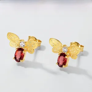 Detailed macro shot of bee earring with S925 silver hallmark and red garnet stone