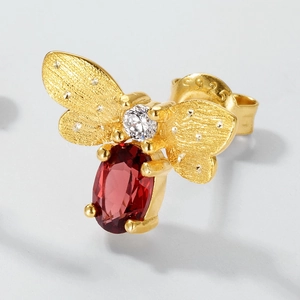 Macro detail of S925 hallmark on a gold-plated bee earring with red garnet gemstone