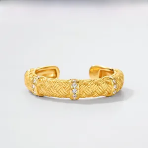 Detail of gold-plated woven texture cuff bracelet with cubic zirconia set on vertical buckles