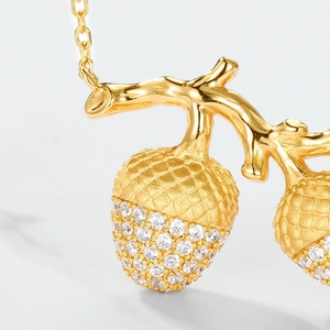 Macro detail of gold hazelnut pendant with intricate scales and sparkling white zircons