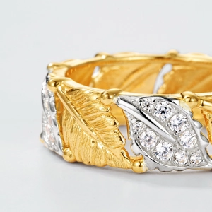Macro view of bicolor leaf ring with brushed gold veins and pavé-set zircons on silver