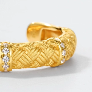 Macro detail of gold-plated S925 silver woven ring with pavé-set round zircons