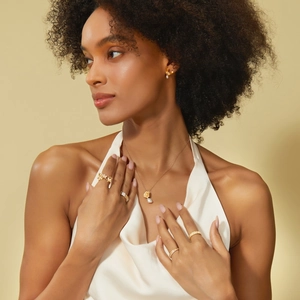 Macro detail of Italian brushed gold maple leaf ring and pearl jewelry set for women