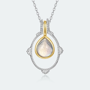 Gros plan sur un pendentif vintage en labradorite poire avec cadre doré et argenté