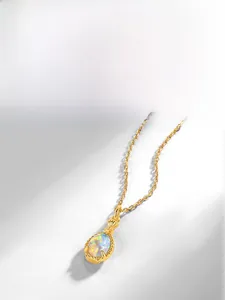 Close-up of a gold perfume bottle pendant necklace featuring a shimmering synthetic opal