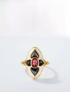 Macro shot of Gothic silver ring with red garnet, black shell and white enamel details