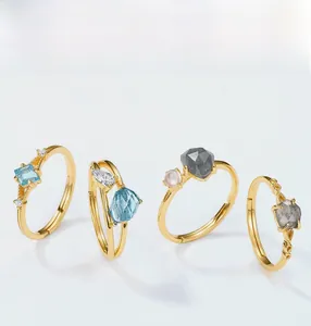 Macro detail of gold S925 silver rings set with blue, grey and pink gemstones