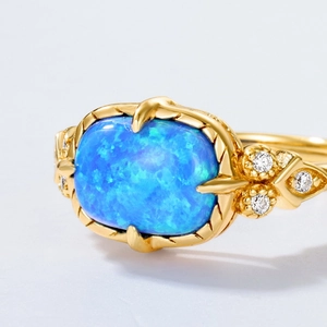 Macro shot of rectangular blue opal ring with vintage gold braided texture and diamonds