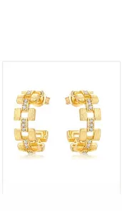Close-up of golden geometric link stud earrings with brushed texture and zircon stones