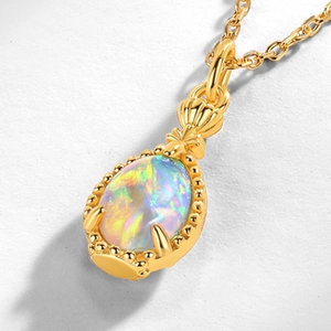 Macro view of gold S925 silver necklace pendant with iridescent opal and shell detail