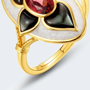Macro detail of garnet ring with black shell inlay and decorative enamel art design