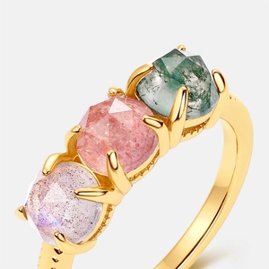 Gold ring featuring three faceted gemstones in green, pink and purple with claw settings
