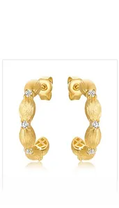 Detail of vintage 10K gold plated 925 silver C-hoop earrings with brushed texture and zircon