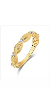 Macro detail of hand-brushed 10K gold-plated 925 silver ring with 5 white cubic zirconia stones