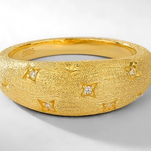 Macro shot of S925 silver gold-plated brushed ring with sparkling star engraving
