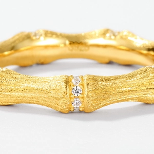 Macro detail of S925 silver bamboo-style ring with brushed gold texture and diamonds