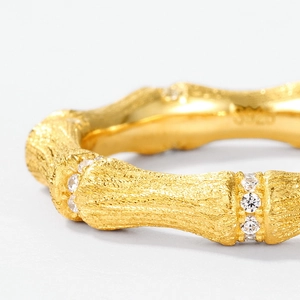 Macro detail of S925 hallmark on brushed gold bamboo ring with micro-set zircons