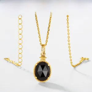 Macro detail of oval smokey quartz pendant with gold beaded bezel and delicate chain link