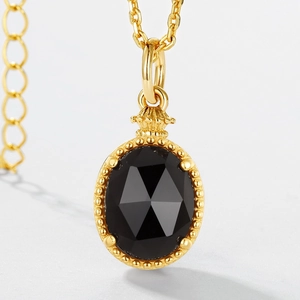 Macro shot of S925 silver gold-plated pendant with faceted oval smoky quartz and crown carving