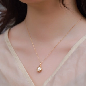 Elegant gold S925 sterling silver necklace with white flower pendant on a female model