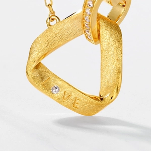 Close-up of S925 silver necklace pendant with brushed gold finish and LOVE engraving