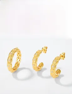Macro detail of brushed gold jewelry set with micro-inlaid zircons and textured finish