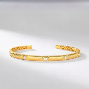 Detailed macro of brushed gold S925 silver bracelet with sunburst zircon inlays